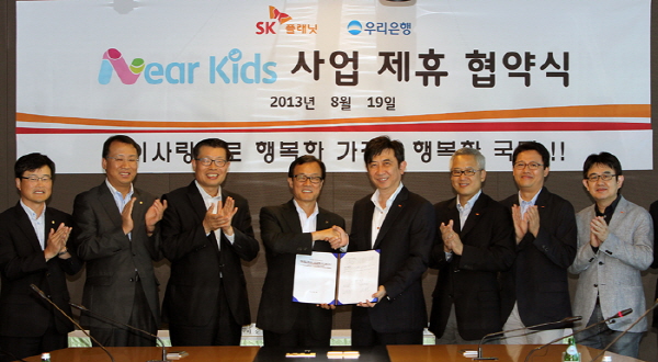 SK플래닛-우리은행, 니어키즈 사업 제휴 협약식 관련 사진입니다. 현수막에 니어키즈 사업 제휴식이라고 적혀있으며 2013년 8월 19일에 시행되었다고 표기되어 있습니다.